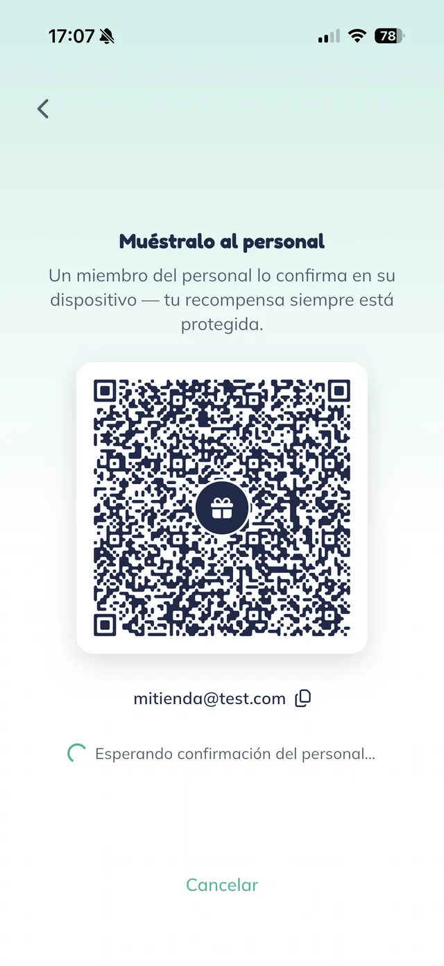 The "Muéstralo al personal" (show this to the staff) screen on the customer’s phone, with a large QR code with a gift icon in its center, the customer’s email below, and the "Esperando confirmación del personal" (waiting for staff confirmation) note.